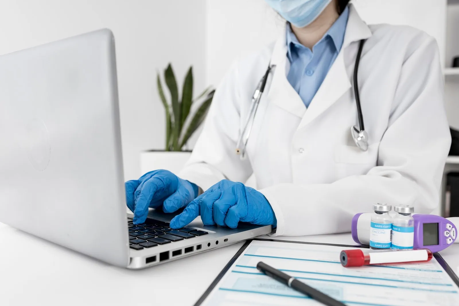 Dentist with latex gloves using a laptop