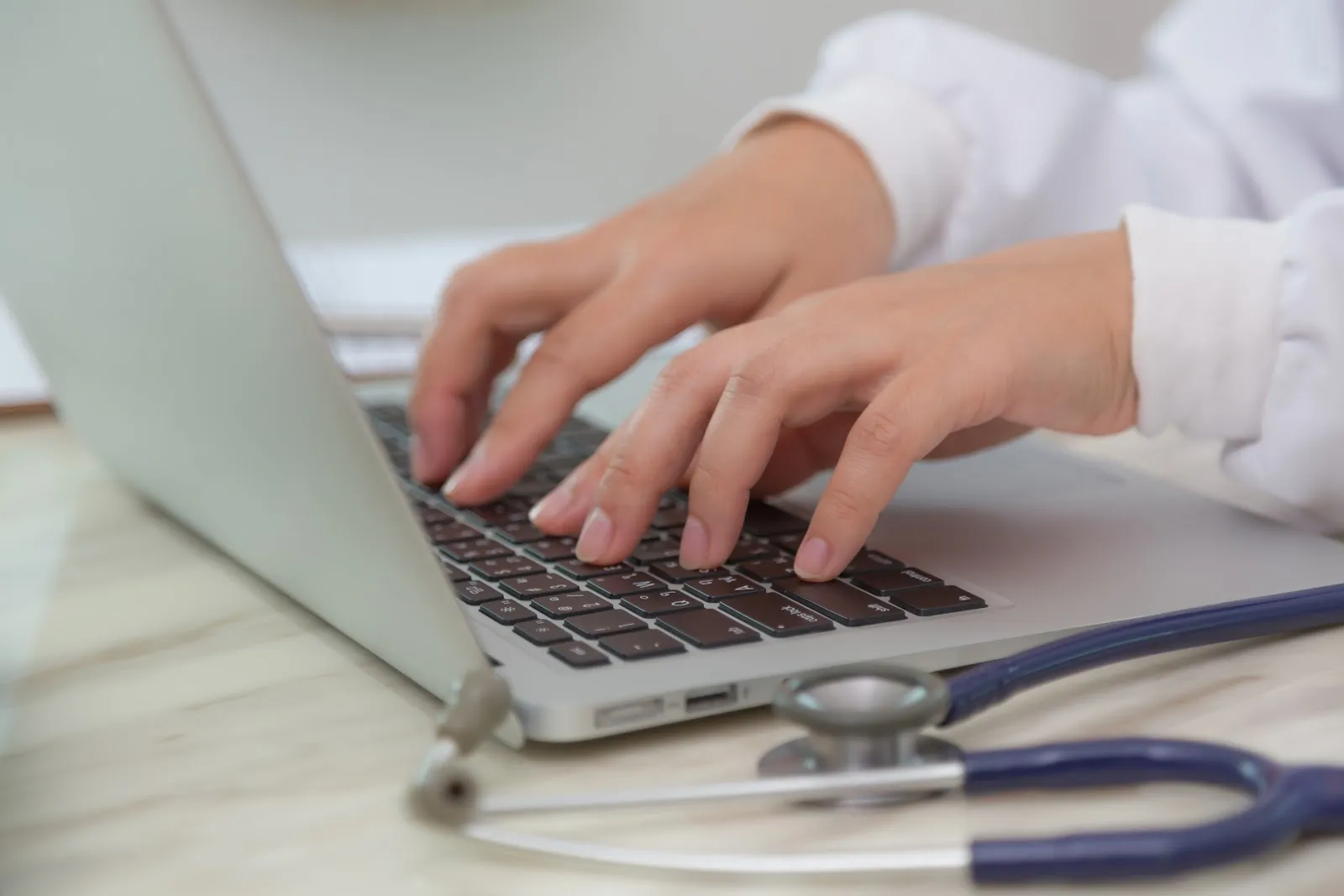 Dentist typing on a laptop